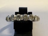 un gros plan d'une bague en diamant posée sur un socle noir