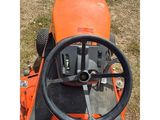 an orange tractor with a steering and steering wheel in the grass