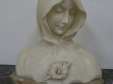 marble statue of a woman with a teddy bear in her lap
