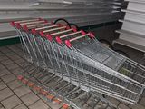 many empty shopping carts sitting in a store aisle
