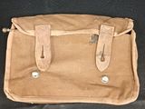 a brown leather bag sitting on a black couch
