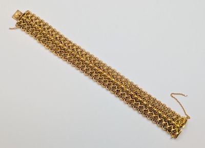 gros plan d'un bracelet en chaîne en or sur une surface blanche