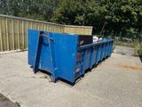 a blue dumpster sitting on the side of the road