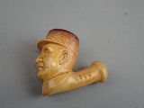 a small carved pipe with a man ' s face on it