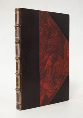 un vieux livre à la couverture rouge posé sur une table