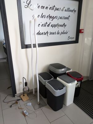 une photo d'une pièce avec des poubelles et une affiche accrochée au mur
