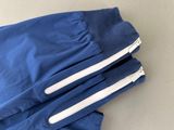 a pair of blue pants with white zippers laying on a table