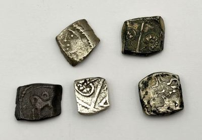 four different types of ancient coins are shown on a white surface