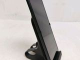 a close up of a cell phone on a stand on a table