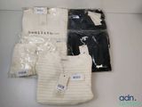 three pairs of sweaters with tags on them sitting on a table