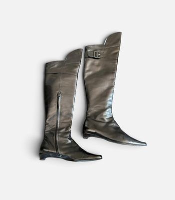 deux paires de bottes noires munies de fermetures éclair, posées sur une surface blanche