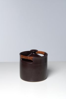 a brown pot with a wooden handle sitting on top of a table