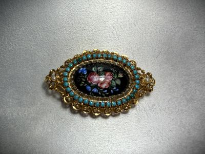 a close up of a broochle with a flower on it