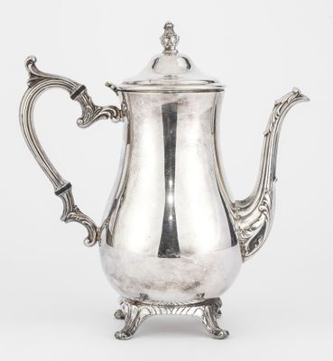 a silver coffee pot with a handle on a stand