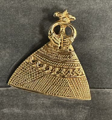 a gold plated pendant with an image of a woman in a dress