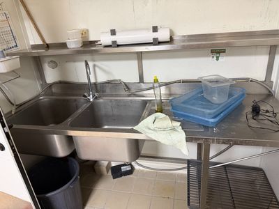 a kitchen with a sink and a trash can on the counter