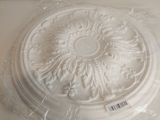 une photo d'un médaillon de plafond blanc posé sur un comptoir