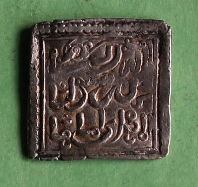 a close up of a metal object on a green surface