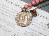 a necklace that has a coin on it with a star on it