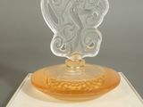 a glass figurine of a woman on top of a box