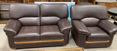 une paire de fauteuils inclinables en cuir marron exposés dans un magasin