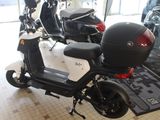 a scooter parked in a showroom with other scooters