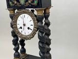 an image of a black and gold clock sitting on top of a table