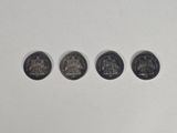 four different coins are arranged in a row on a white surface
