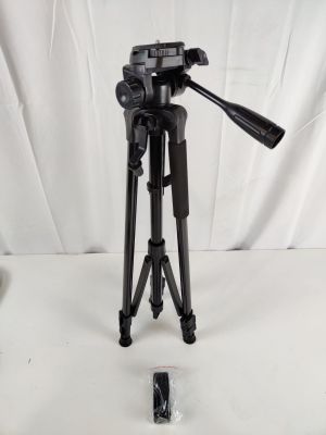 a black tripod sitting on top of a white table next to a camera