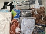 many different types of clothes in bags on a shelf