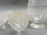 three glasses and a pitcher sitting on a table