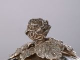 a silver plate with a flower on it on a table
