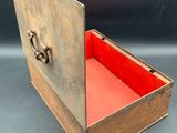 an old wooden box with a red lid on a black background