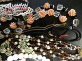 a lot of beads and necklaces that are on a table