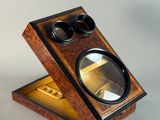 a small wooden box with a magnifying glass in it