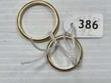 two gold wedding rings with a price tag on a white background