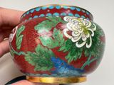 a hand holding a vase that has a flower on it
