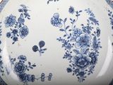 a large blue and white plate with flowers on it