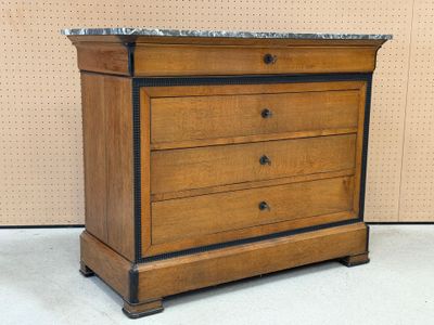 a wooden chest of drawers with a marble top
