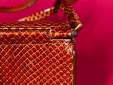 an image of a brown purse on a pink background