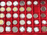 an assortment of silver and gold coins in a red box