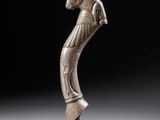 a bronze statue of a woman holding a tennis racket