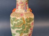 un vase avec un tableau posé sur une table