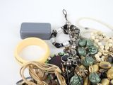 a pile of assorted jewelry on a white surface