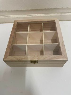 une petite boîte en bois à compartiments posée sur une table