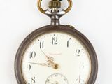 a pocket watch hanging from a rope on a white wall