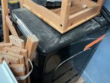 a stack of wooden chairs and a washing machine in a room