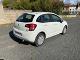a small white car parked on the side of the road