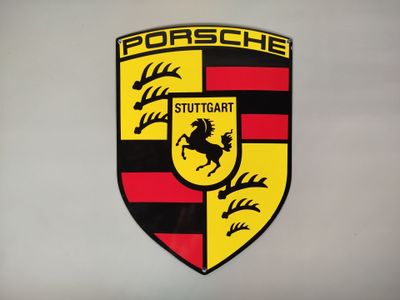 un gros plan sur l'emblème Porsche accroché au mur