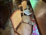 four wicker chairs sitting in front of a wooden table